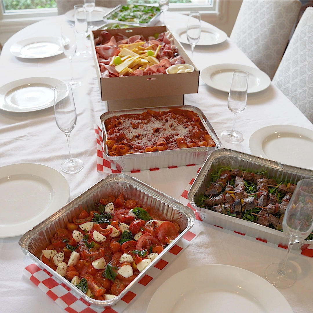 Pizza, sliders, arancini and a cured meat platter laid out on a table.